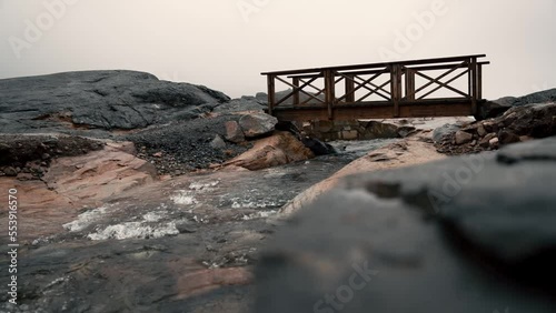 Small wooden bridge over flowing water, on the mountain 