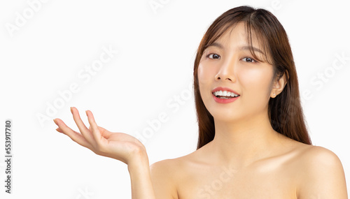 Beauty and spa treatment concept. Asian beautiful woman long hairstyle clean fresh face posing hand pointing white background.