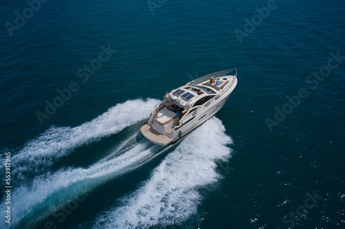 Big white yacht with people moving on blue water top view. Summer travel on a yacht aerial view. Yacht in the sea aerial view. © Berg