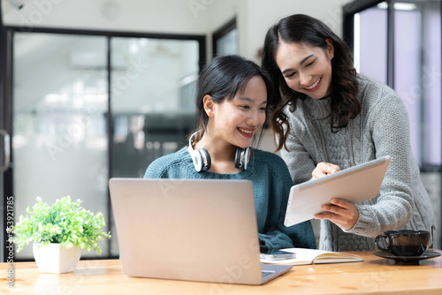 Two young Asian businesswoman discuss financial management planning. new startup project ideas analysis of financial planning and statistics and the investment market at the office