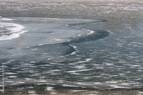 the river is under ice on a sunny frosty day