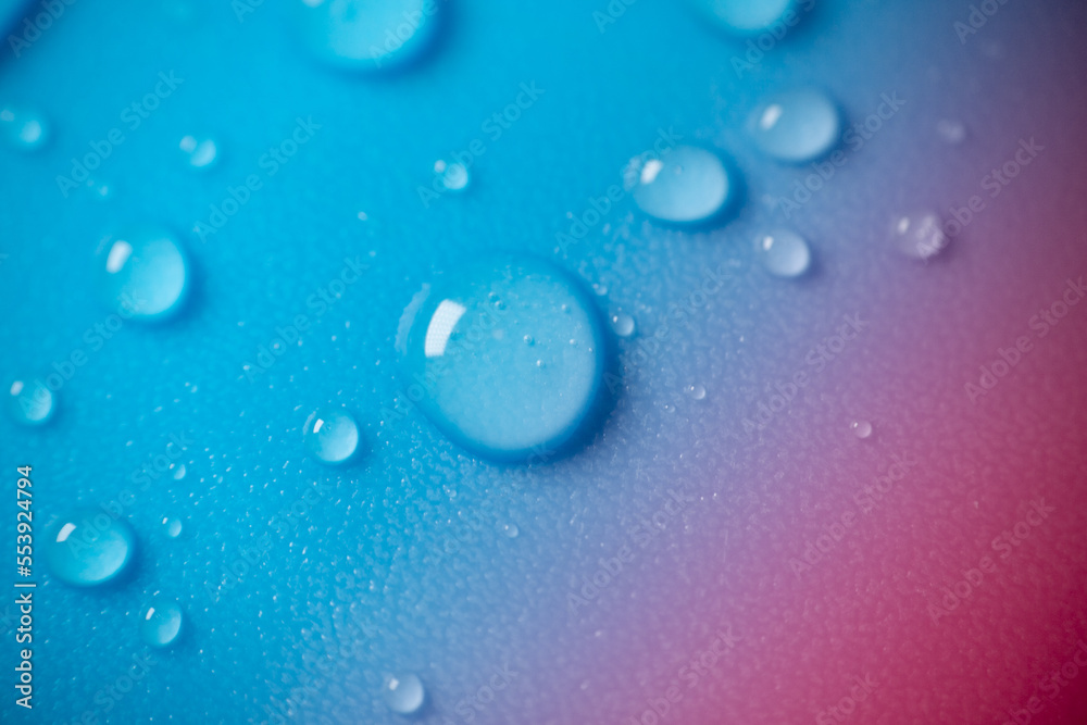water drops on a blue background with a pink gradient.Fluid texture in cold blue tones.Wallpaper blau phone.macro drops set