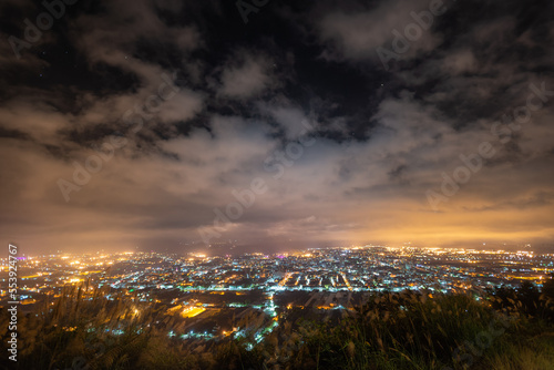 Hazy and dreamy night view of the city. The orange glow of the fog. A night view of the city shrouded in clouds. New Taipei, Taiwan © twabian