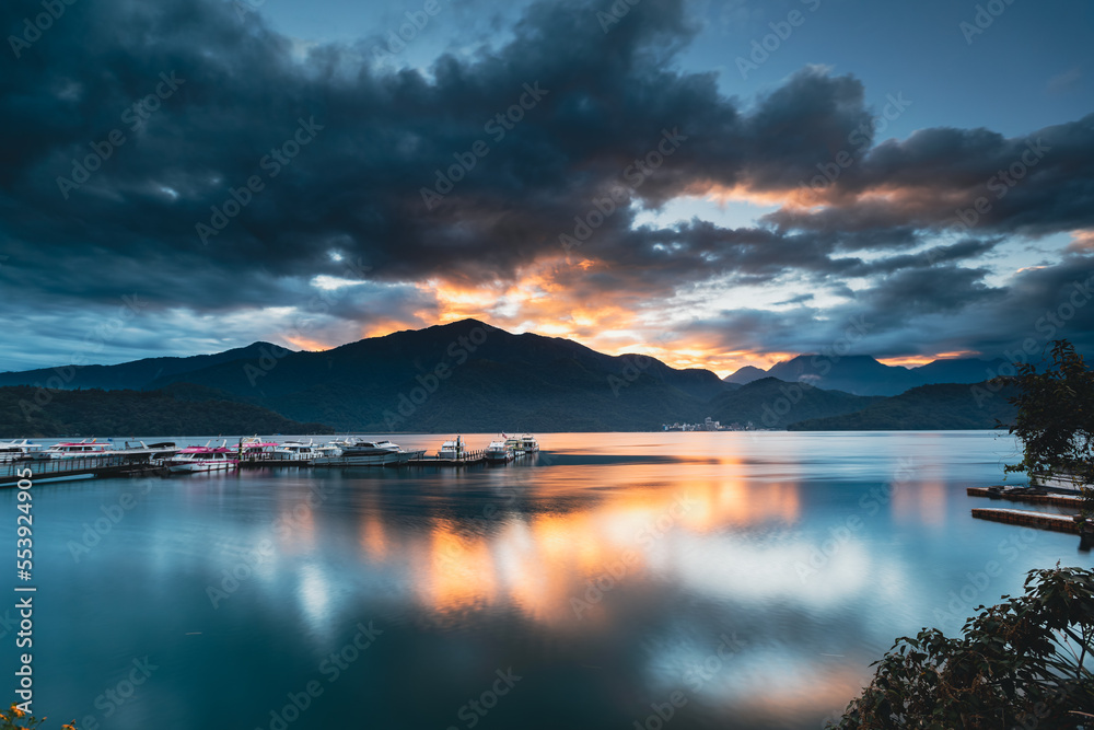 Romantic view of sunrise with crimson clouds. Beautiful lakes and mountains. Chaowu Pier, Sun Moon Lake National Scenic Area. Nantou County, Taiwan
