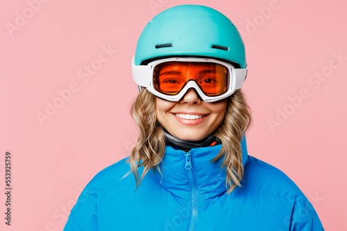 Snowboarder smiling happy fun woman wear blue suit goggles mask hat ski padded jacket helmet look camera isolated on plain pastel pink background Winter extreme sport hobby weekend trip relax concept