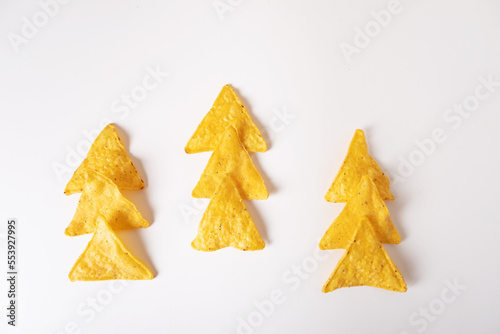 Mexican corn chips nachos laid out in the form of a Christmas tree on a white background