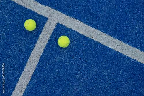 two tennis balls on a blue turf court paddle tennis court © Vic