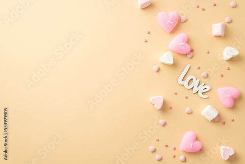 St Valentine's Day concept. Top view photo of inscription love heart shaped marshmallow pink candles and sprinkles on isolated pastel beige background with empty space
