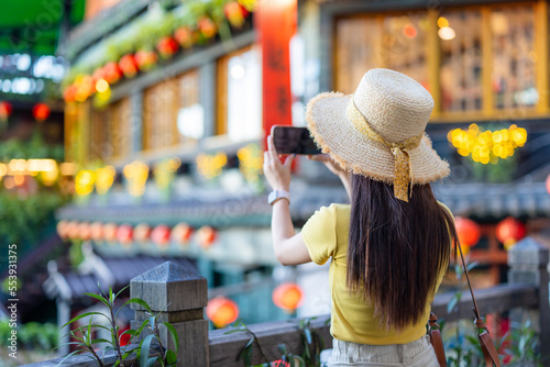 Tourist woman take photo on cellephone in Jiufen village in Taiwan photo