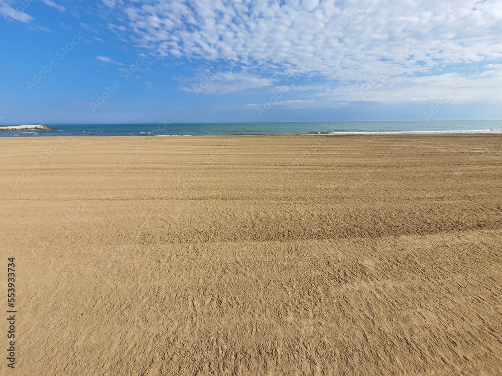 Fototapeta premium Wonderful empty and wide open beachfront on a sunny day with some clouds. space for text.