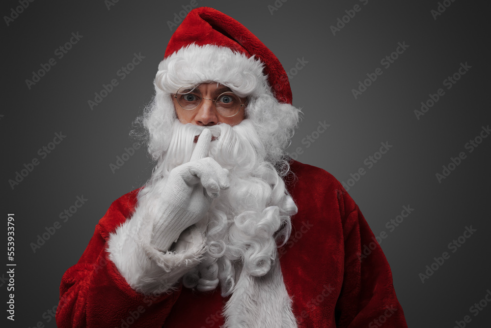 Shot of isolated on grey santa claus posing with finger at his lips. Shot of isolated on grey santa claus posing with finger at his lips.