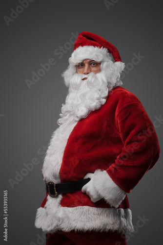 Studio shot of cheerful elderly santa dressed in red winter costume. © Fxquadro