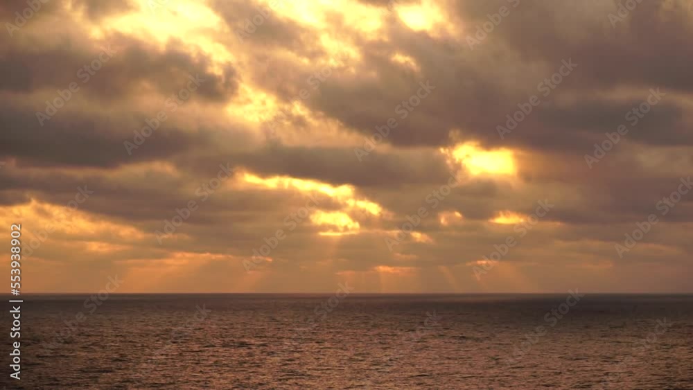 Sea horizon line with waves on golden sunset. Golden hour waves under storm clouds. Close-up on ocean waves roll to rocky volcanic shore in stormy weather. Abstract holiday nature, no people Sea horizon line with waves on golden sunset. Golden hour waves under storm clouds. Close-up on ocean waves roll to rocky volcanic shore in stormy weather. Abstract holiday nature, no people