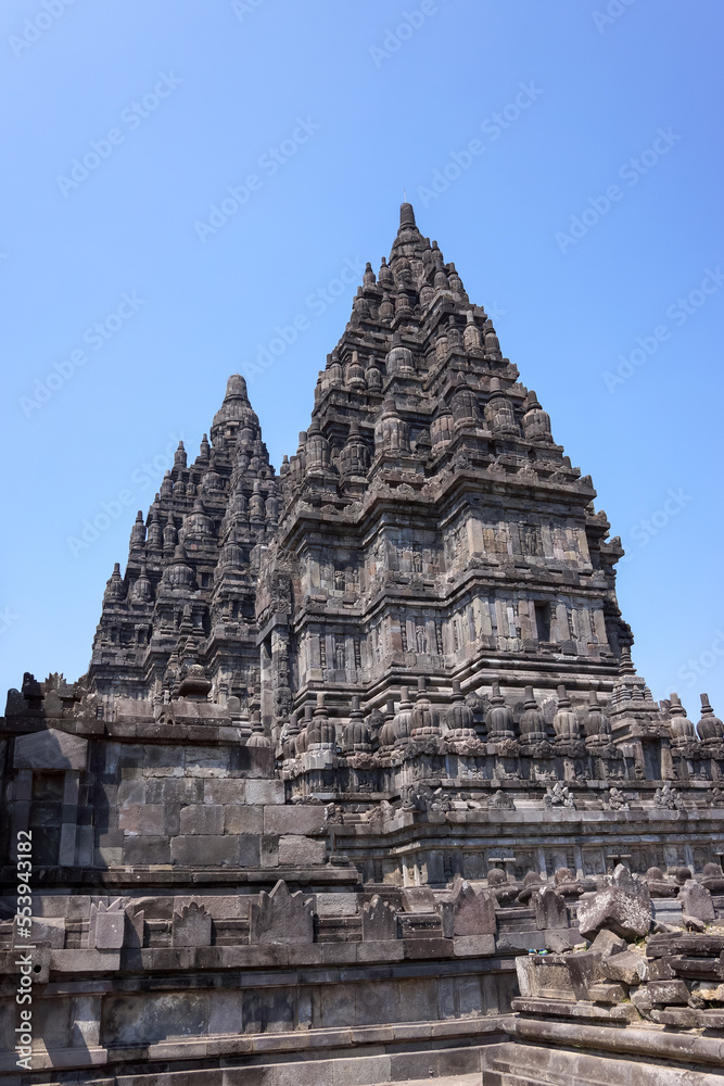 View of ancient hindu Prambanan Temple complex with sunny clear blue sky background. No people.