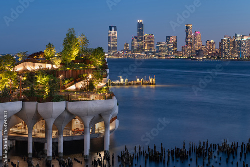 New York City, Little Island public park in evening with view of Downtown Jersey City. Elevated park at Hudson River Park (Pier 55), West Village, Manhattan photo