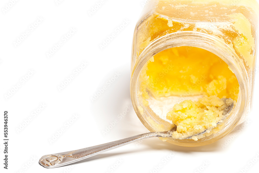 Ghee in jar and spoon isolated on white background. Ghee in jar and spoon isolated on white background.