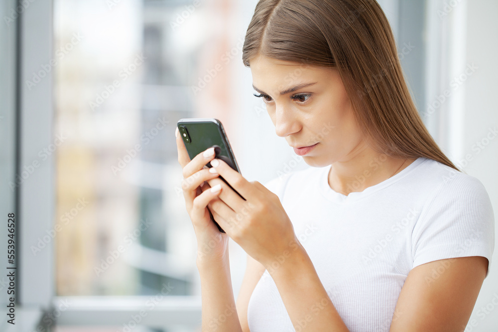 Attractive woman looking at smartphone screen, reading media news