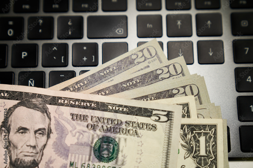 five-dollar bill with Lincoln portrait on computer keyboard five-dollar bill with Lincoln portrait on computer keyboard