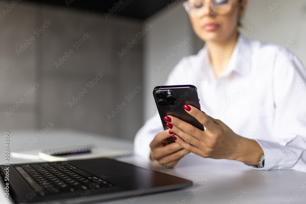 Young woman use a laptop to work in the kitchen use the phone at home Young woman use a laptop to work in the kitchen use the phone at home