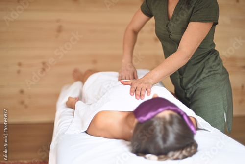Woman practicing tui na massage on woman's body with her hands on her chest.