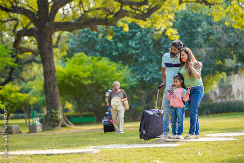 Indian family with suitcase. ready for holidays.