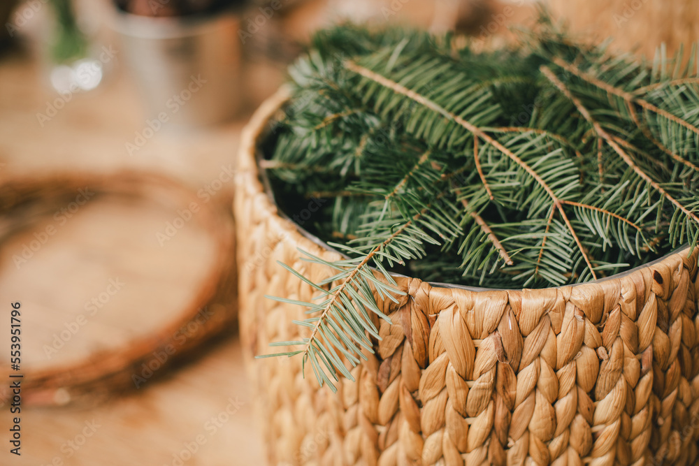 Pine branches in wicker basket.