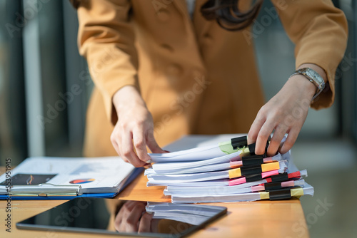 Close-up hand of Asian businesswoman arranging documents on her desk