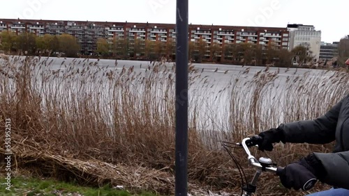 Copenhagen, Denmark A woman bikes along  the Svineryggen bike path on Sankt Jorgens Lake photo