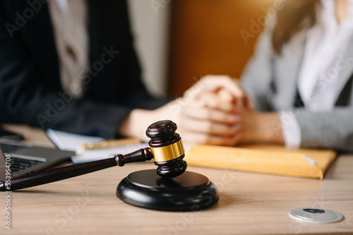 Female lawyer in the office with brass scale on wooden table. justice and law concept