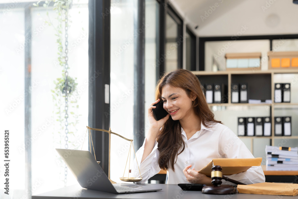 woman and lawyers discussing contract papers with brass scale on wooden desk in office. woman and lawyers discussing contract papers with brass scale on wooden desk in office.