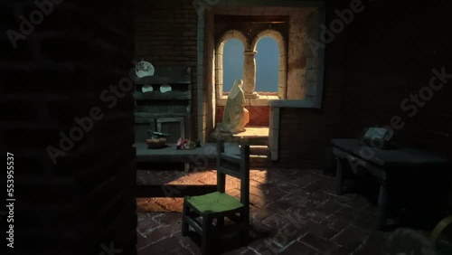 Representation of religious scene of nun painted figurine praying kneeling at convent window. Zoom in