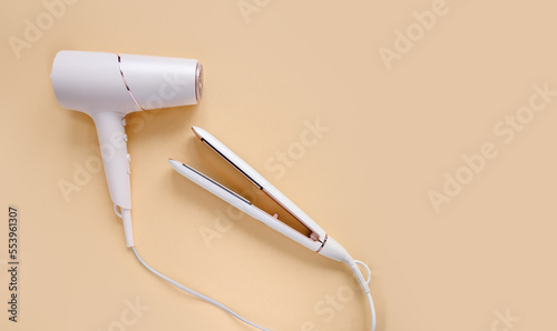 Foto Top view of hair straightener and hair dryer on beige background