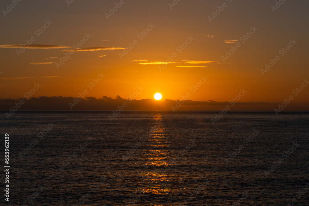 Obraz premium background of ocean landscape with a golden sun over a calm ocean
