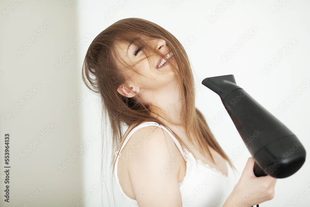 Beautiful woman using a hair dryer and enjoying in hotel room. Beautiful woman using a hair dryer and enjoying in hotel room.