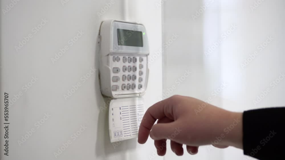 Hand entering alarm system password of an apartment, home or business office. Surveillance and protection console against rubbery and thief