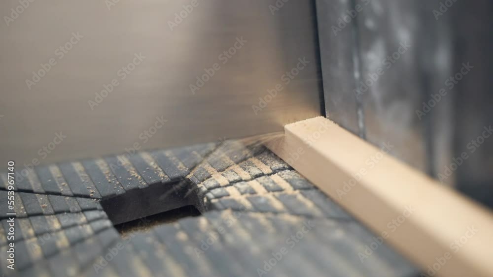 Close up shot of carpenter's hand using saw for cutting thin wooden profile on two parts, man cutting board and forming sawdust. Raw wooden material for processing, work with wood at the factory Close up shot of carpenter's hand using saw for cutting thin wooden profile on two parts, man cutting board and forming sawdust. Raw wooden material for processing, work with wood at the factory