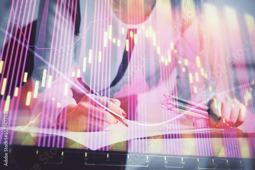 Double exposure of hands making notes with forex chart huds. Stock market concept.