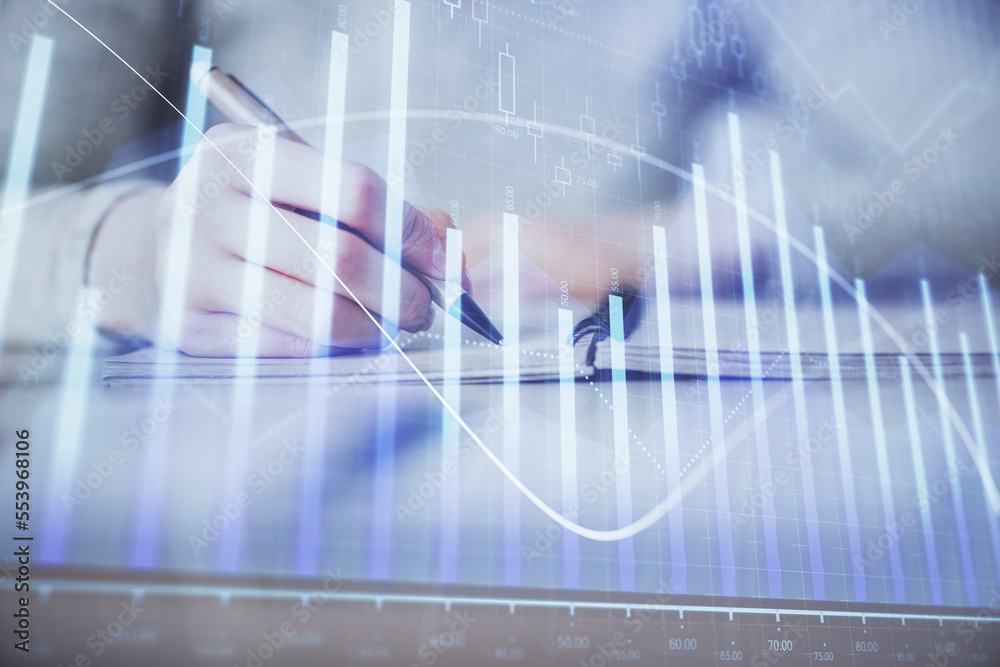 Hands writing information about stock market in notepad. Forex chart holograms in front. Concept of research. Multi exposure Hands writing information about stock market in notepad. Forex chart holograms in front. Concept of research. Multi exposure