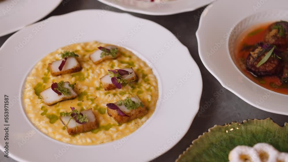 Plate of seared scallops on table, slow pan tight Plate of seared scallops on table, slow pan tight