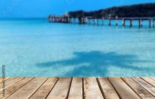 Wooden table top on blur blue sea  background in summer season.For montage product display or design key visual layout.View of copy space.