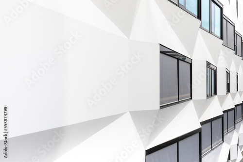 Building with white walls with black framed windows in perspective of with polygonal geometric shapes. Modern architecture. minimalist design with copy space. City  White wall with natural light.