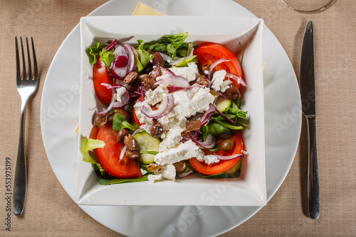 Insalata greca con feta, pomodori, cipolle rosse, cetrioli, pomodori e lattuga servita in un ristorante elegante