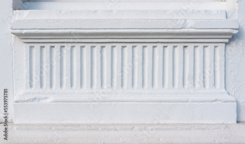 Rayas en relieve en estuco ornamental en fachada blanca photo