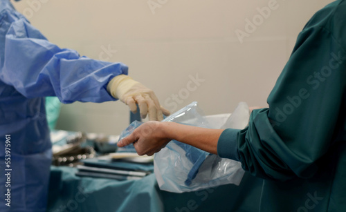 Team of doctor and nurse in the operating room. Nurse helping the doctor before starting the surgery