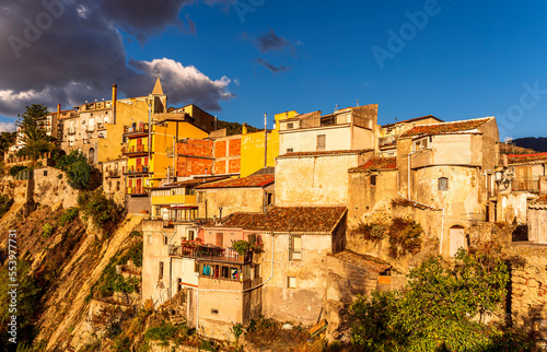 old mediterranean mountain dense town with levels of yellow houses and terraces on a mountain in evening light, vintage european village on a rock © Yaroslav