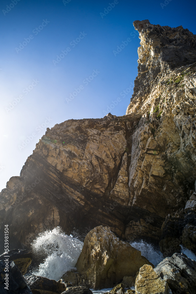 Cliffs, sharp spectacular rocks rising from the ocean. waves. Ursa sandy beach under the cliff. Sunny day. Horizontally Cliffs, sharp spectacular rocks rising from the ocean. waves. Ursa sandy beach under the cliff. Sunny day. Horizontally