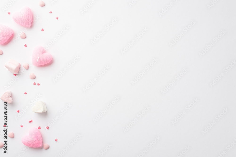 Valentine's Day concept. Top view photo of heart shaped marshmallow pink candles and sprinkles on isolated white background with blank space Valentine's Day concept. Top view photo of heart shaped marshmallow pink candles and sprinkles on isolated white background with blank space