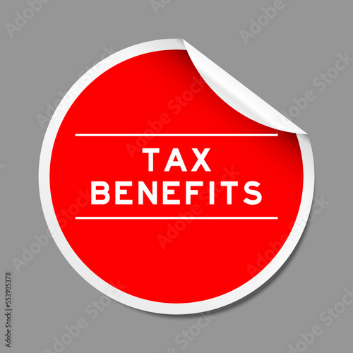 Red color peel sticker label with word tax benefits on gray background