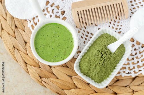 Matcha powder and homemade green tea (kelp, algae, spirulina) face or eye mask (scrub) in a small white bowl. Natural beauty treatment and spa recipe. Top view.