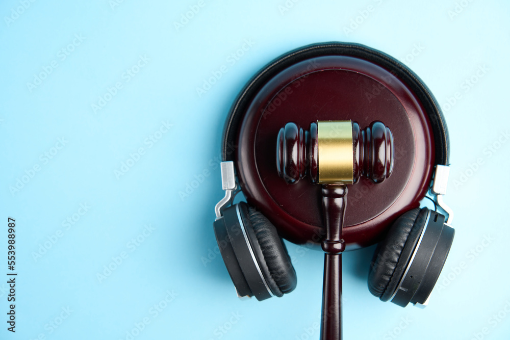 Headphones and judge gavel background with copy-space Headphones and judge gavel background with copy-space